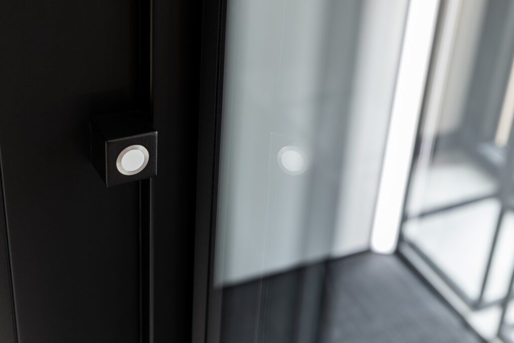 Detail van de liftdeur met magnetische sluiting en strak zwart frame.